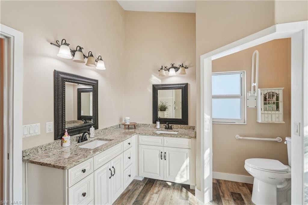 Full bathroom featuring double vanity and wood finished floors
