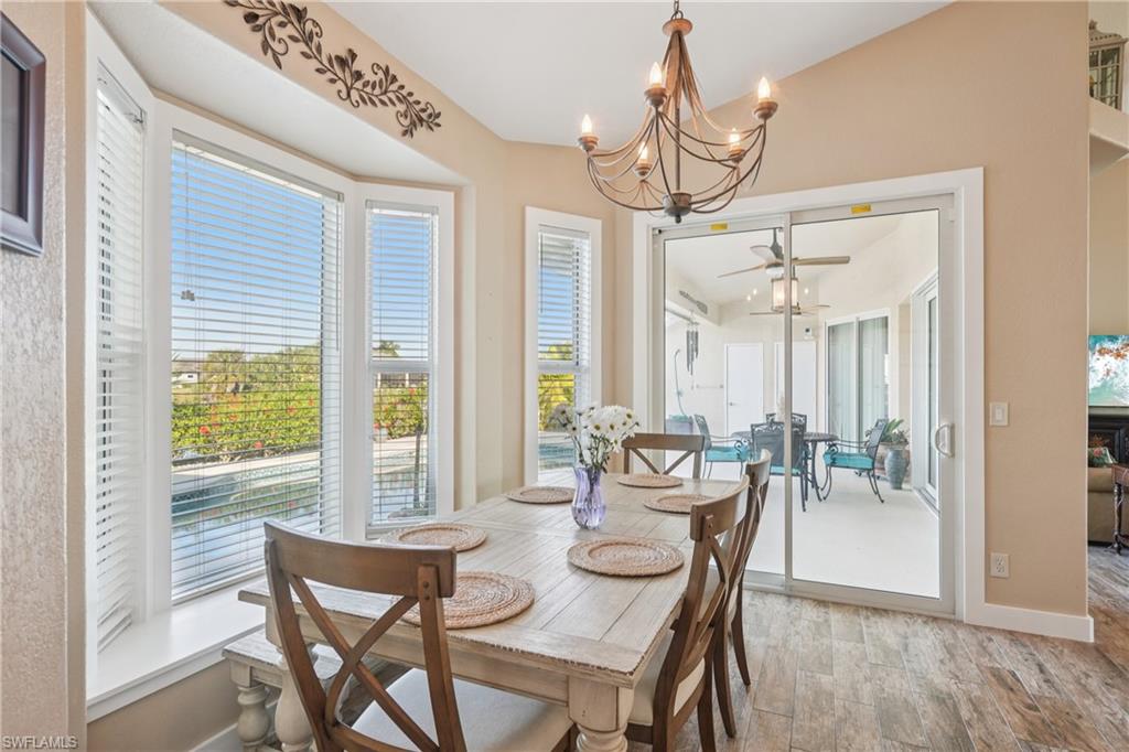 Dining space with a chandelier, ceiling fan, and light wood-type flooring
