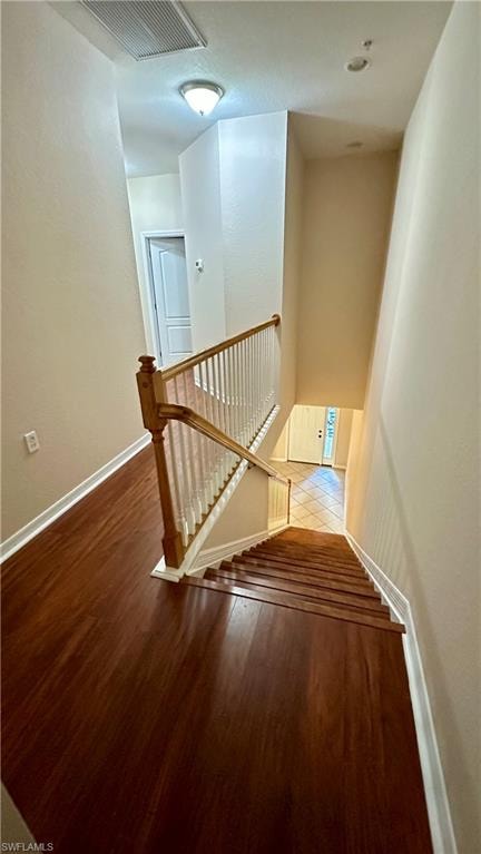 Staircase with wood finished floors and baseboards