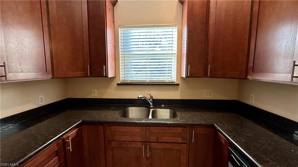 Kitchen with dark stone countertops and brown cabinetry