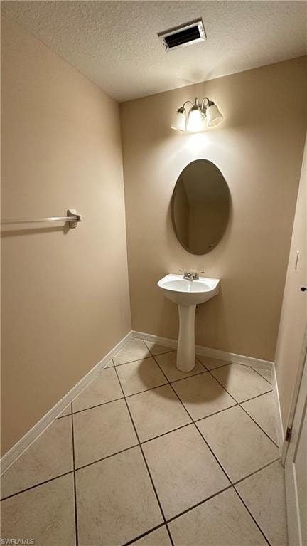 Bathroom featuring a textured ceiling and light tile patterned flooring