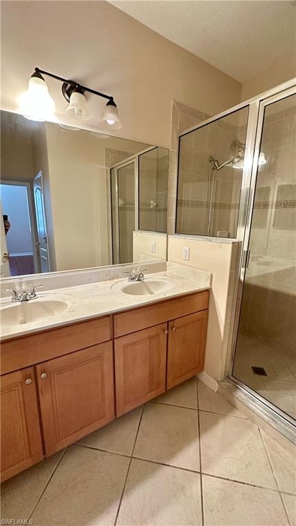 Full bathroom featuring double vanity, a shower stall, light tile patterned floors, and a textured ceiling