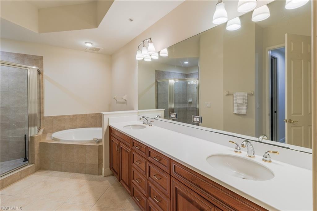 Primary en-suite bathroom with dual vanity, soaking tub and walk in shower with a water closet