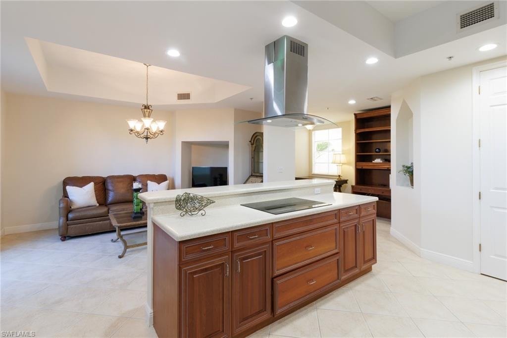 Large kitchen island with cooktop and bartop.