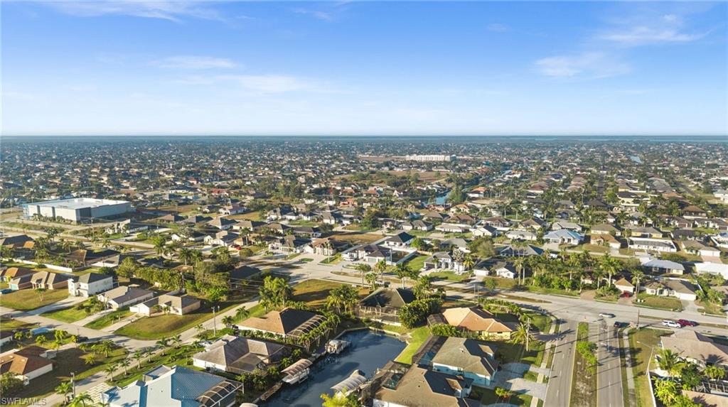 Aerial view of property and surrounding area with nearby suburban area