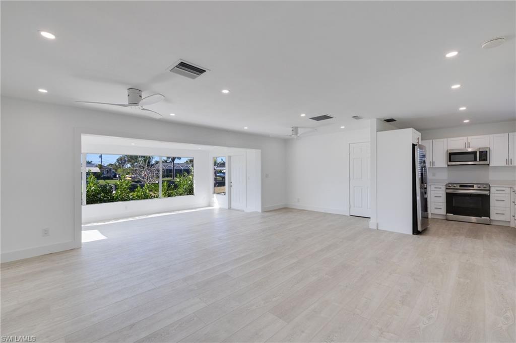 Unfurnished living room featuring light wood-type flooring, a ceiling fan, and recessed lighting