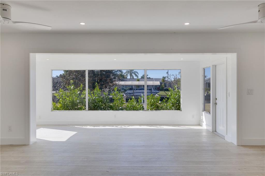Unfurnished room featuring a ceiling fan, healthy amount of natural light, light wood-style floors, and recessed lighting