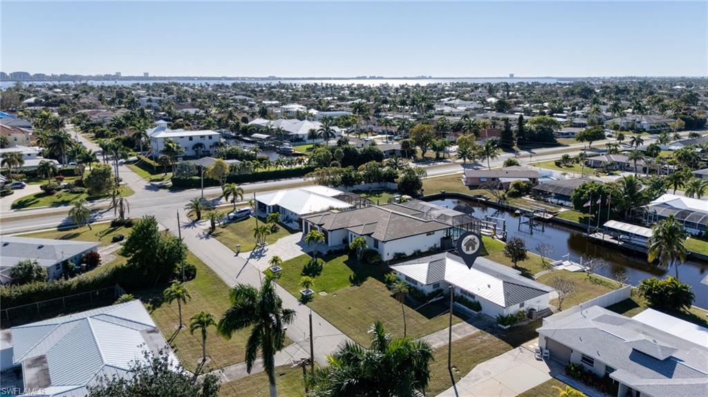 Aerial view of residential area featuring a nearby body of water