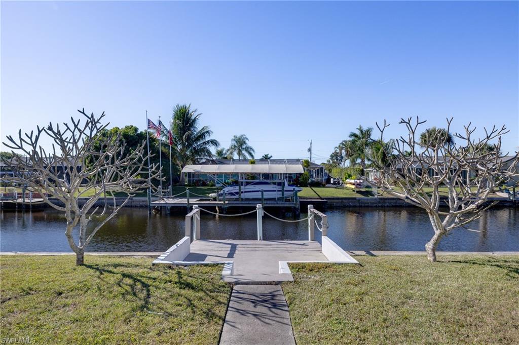 Dock area featuring a yard, boat lift, and a water view