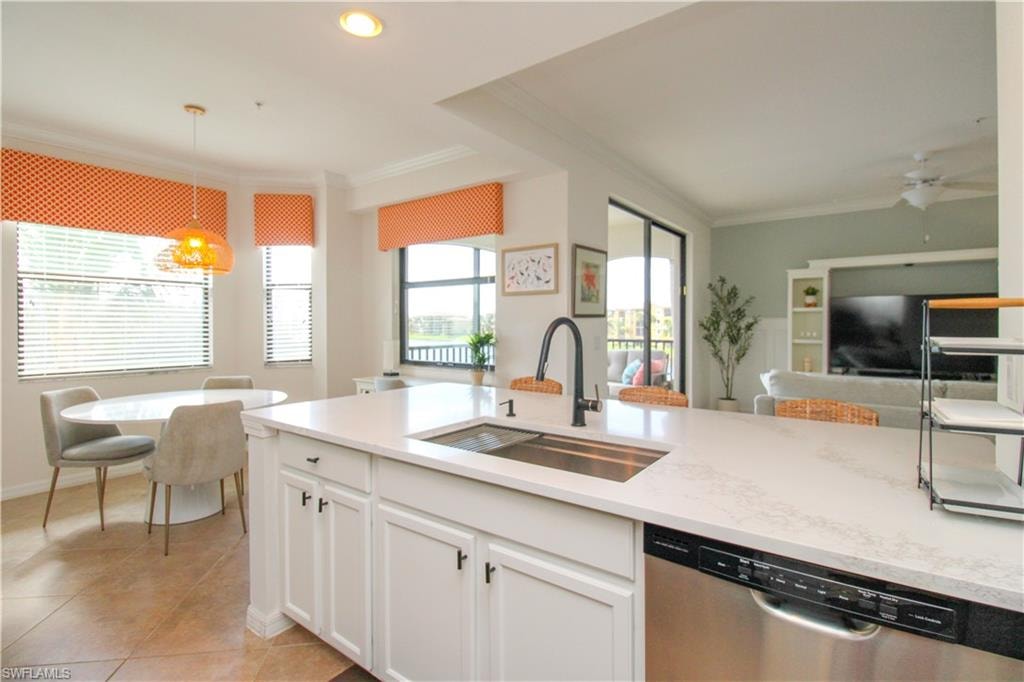 Kitchen with white cabinets, ceiling fan, sink, dishwasher, and hanging light fixtures