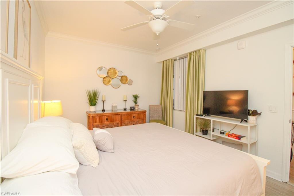 Bedroom featuring wood-type flooring, ceiling fan, and crown molding