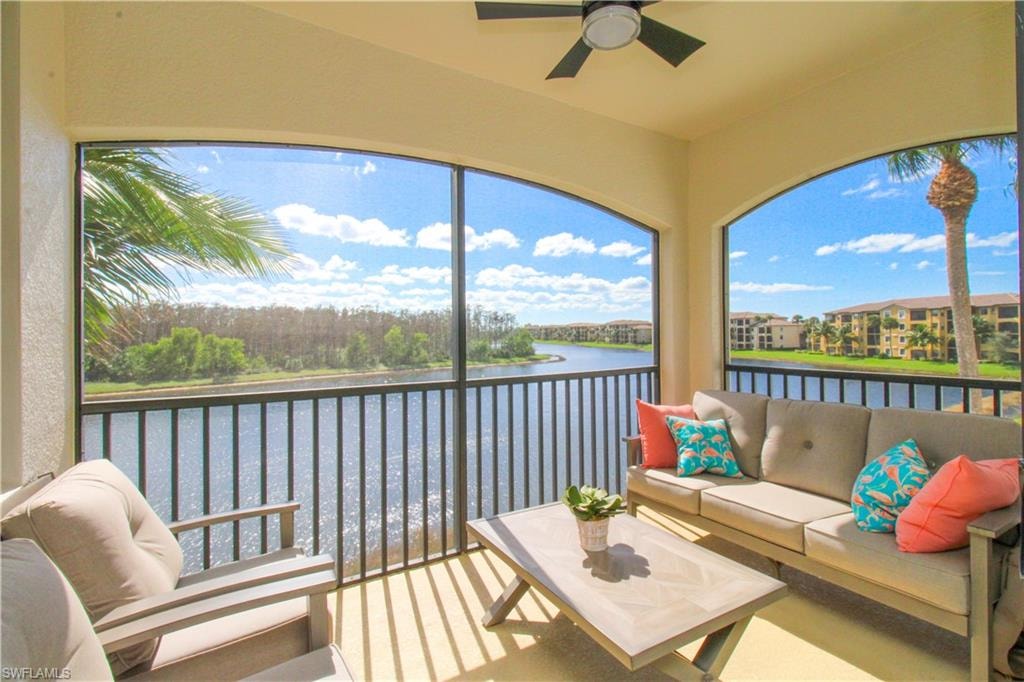 Sunroom with ceiling fan and a water view