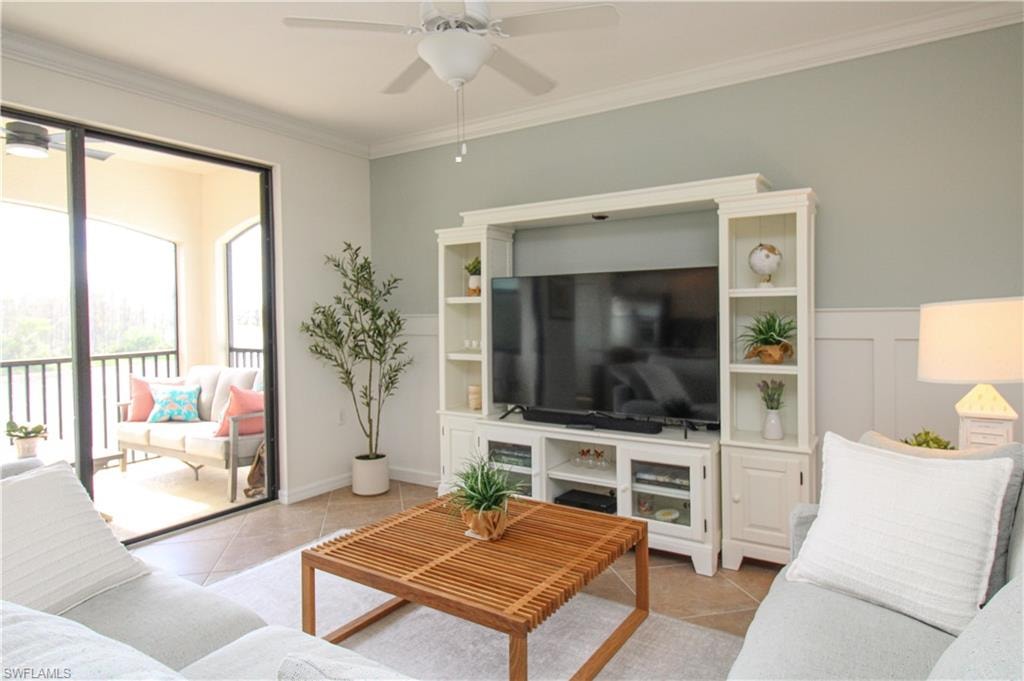 Tiled living room with ceiling fan and ornamental molding