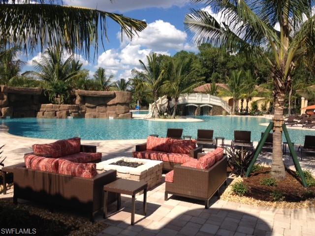 View of pool featuring a patio area, pool water feature, and an outdoor living space with a fire pit