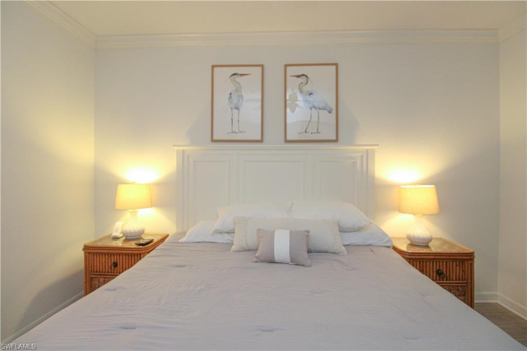Bedroom with hardwood / wood-style floors and ornamental molding