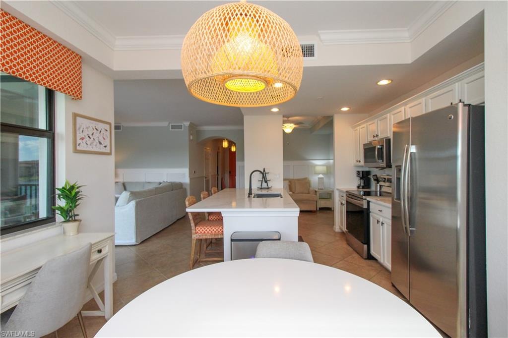 Kitchen featuring crown molding, white cabinetry, sink, and appliances with stainless steel finishes