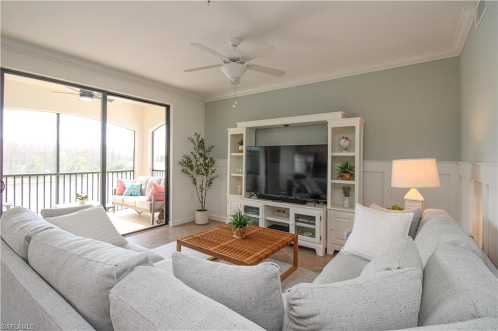 Living room featuring ceiling fan, light tile patterned floors, and ornamental molding