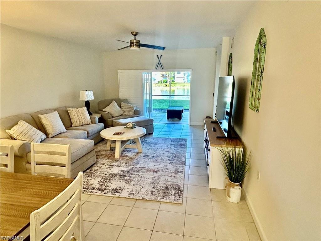 Living room with light tile patterned floors and ceiling fan