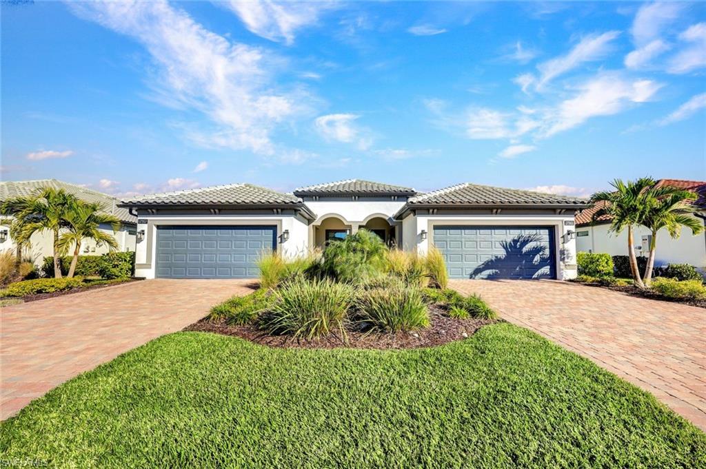 Mediterranean / spanish-style house featuring stucco siding, a tiled roof, an attached garage, and decorative driveway