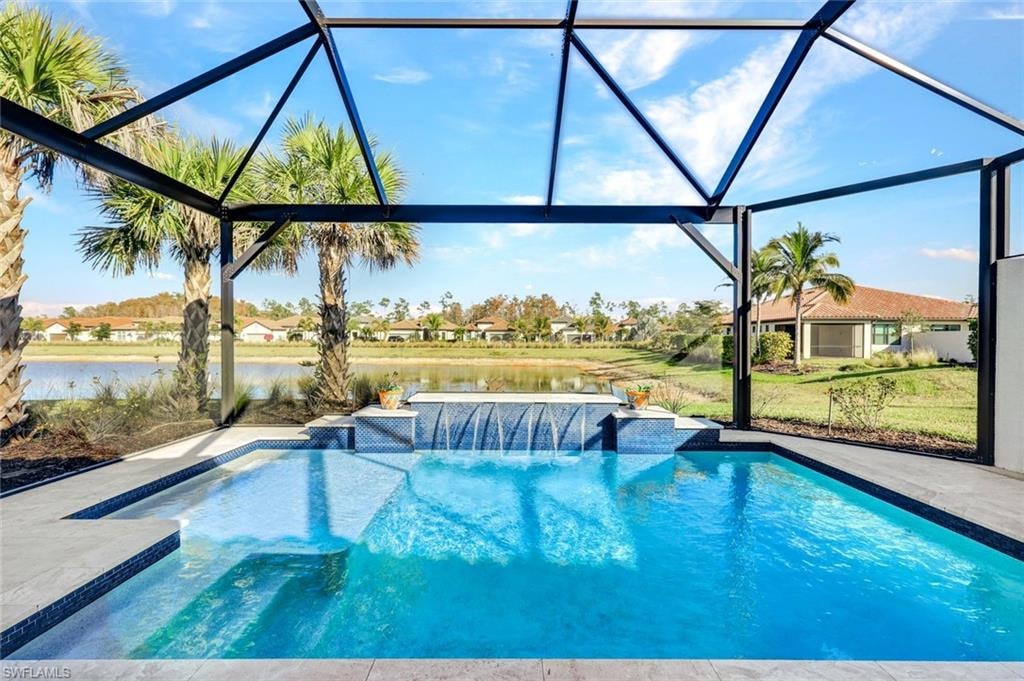 Outdoor pool featuring glass enclosure, a water view, and a sunroom