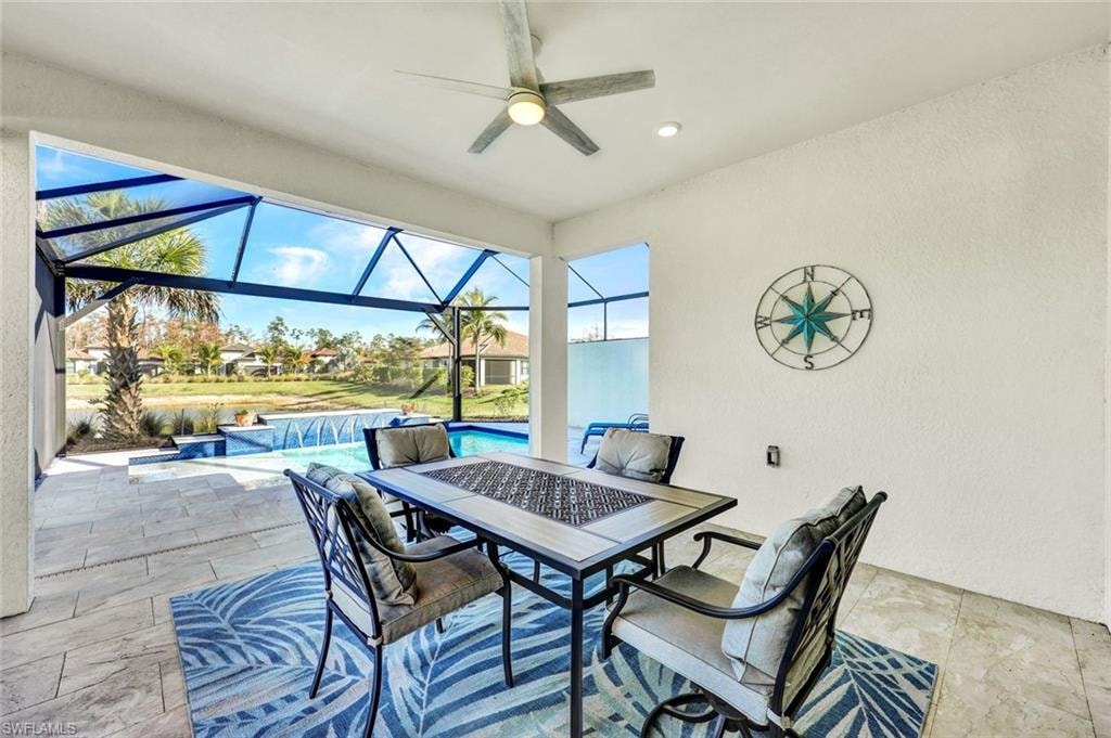 View of patio / terrace featuring a sunroom, a ceiling fan, an outdoor pool, outdoor dining area, and glass enclosure