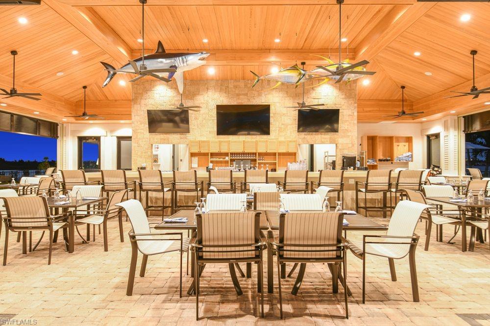 Dining area featuring high vaulted ceiling, a ceiling fan, a wood ceiling with exposed beams, brick floors, and recessed lighting