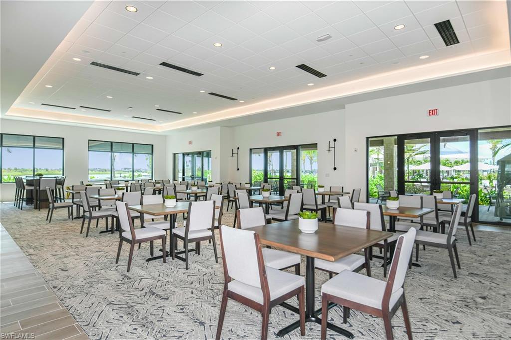 Dining space with recessed lighting, healthy amount of natural light, a raised ceiling, wood tiled floors, and a towering ceiling