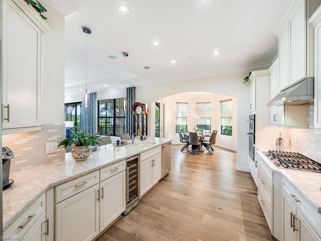 Kitchen featuring tasteful backsplash, pendant lighting, a peninsula, arched walkways, and recessed lighting