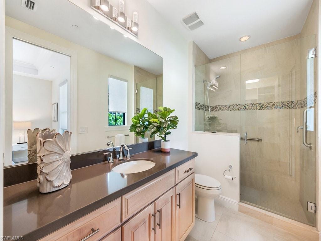 Bathroom featuring vanity, a stall shower, light tile patterned floors, and recessed lighting