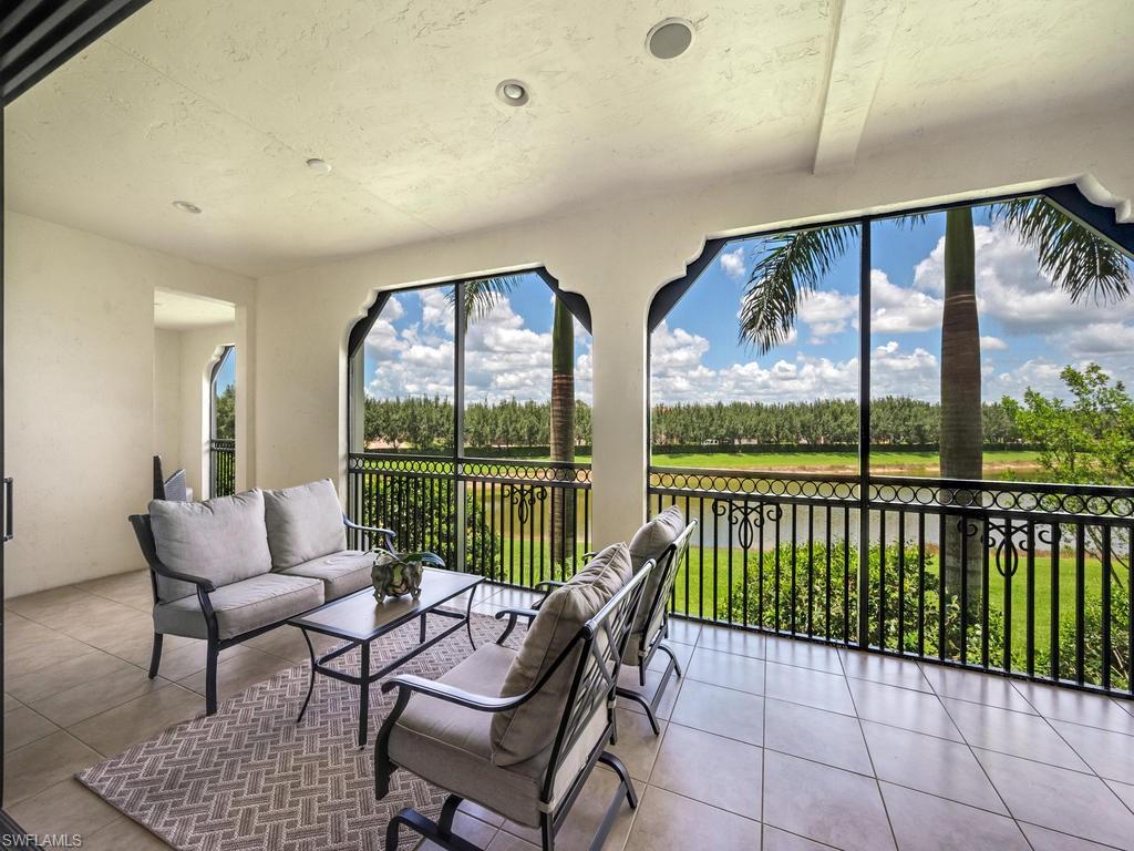 Sunroom / solarium with view of wooded area and a water view