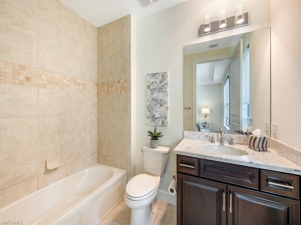 Bathroom featuring vanity, washtub / shower combination, and light tile patterned floors