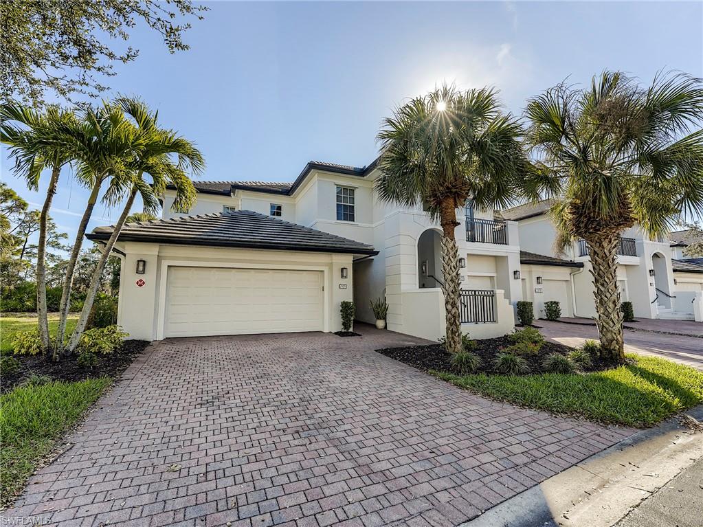 View of front of house with decorative driveway, an attached garage, and stucco siding