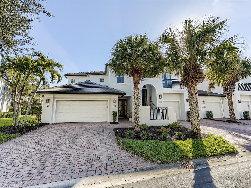 Mediterranean style house featuring decorative driveway, stucco siding, and an attached garage