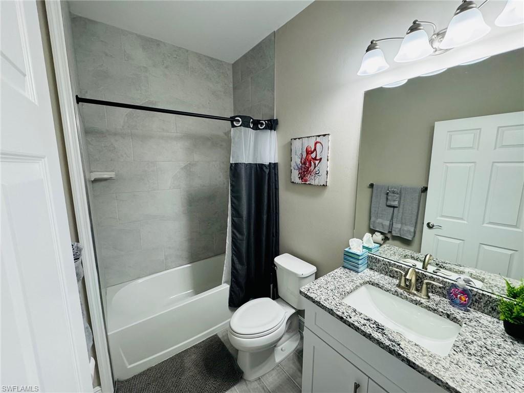 Full bathroom featuring vanity and shower / bathtub combination with curtain