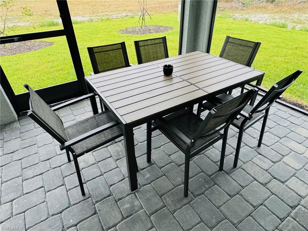 Sunroom / solarium with outdoor dining area and a patio
