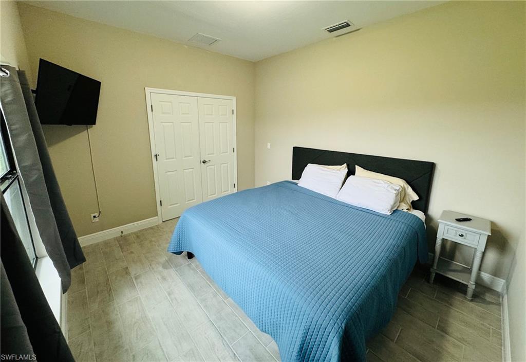Bedroom with wood finish floors and a closet