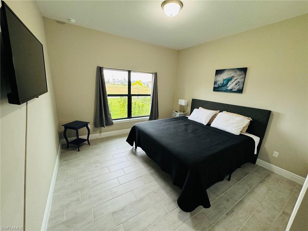 Bedroom featuring baseboards and wood tiled floors