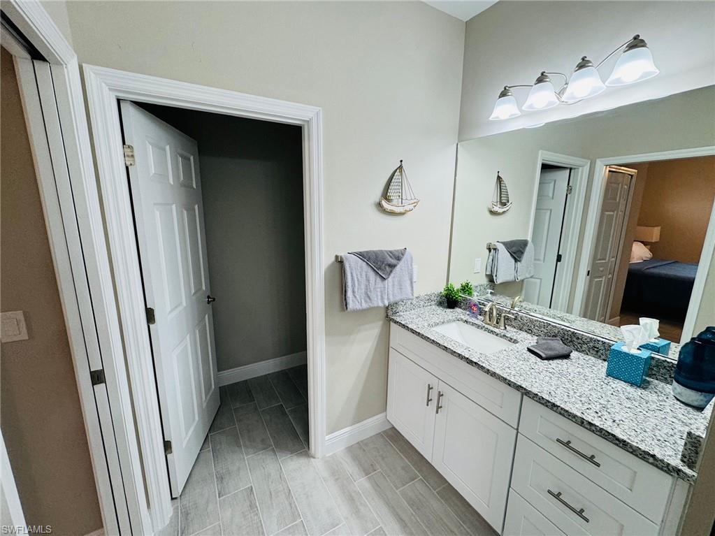 Ensuite bathroom featuring vanity and wood tiled floors