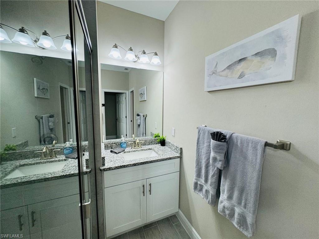 Full bathroom with vanity and baseboards