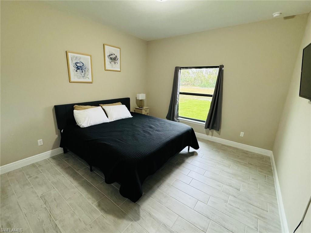 Bedroom with wood finish floors and baseboards