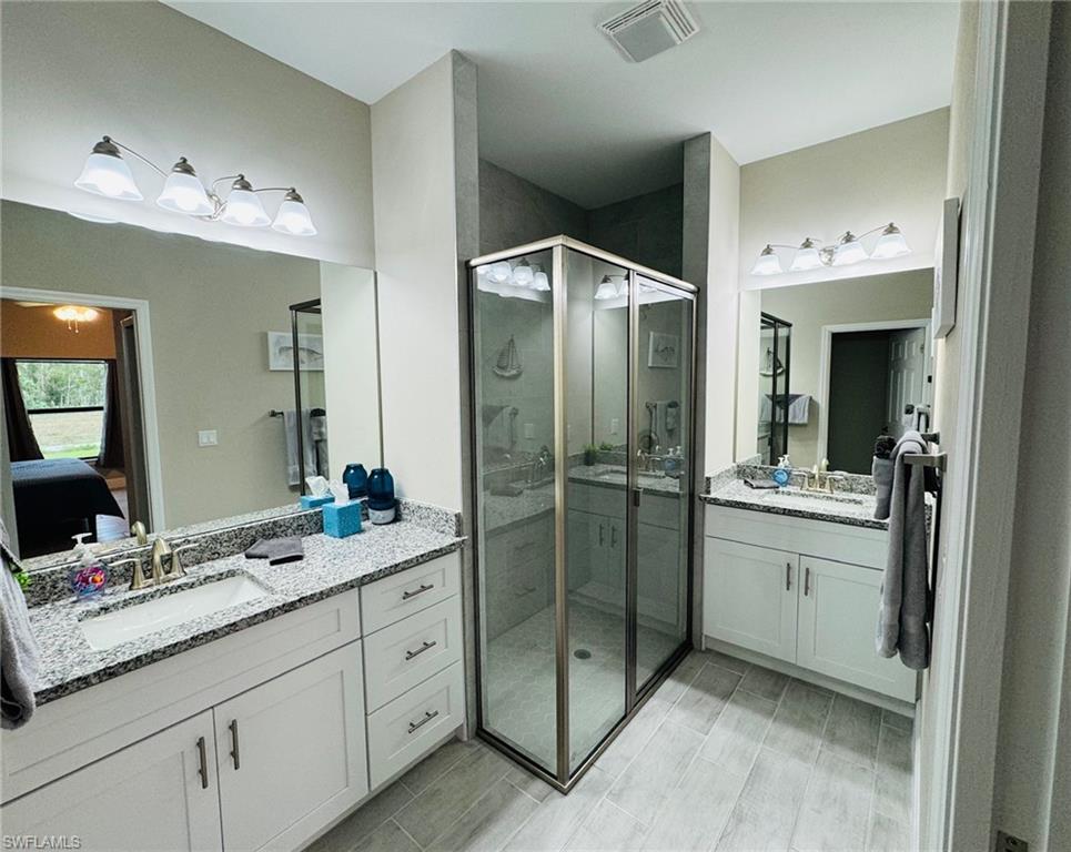 Ensuite bathroom with two vanities and a shower stall