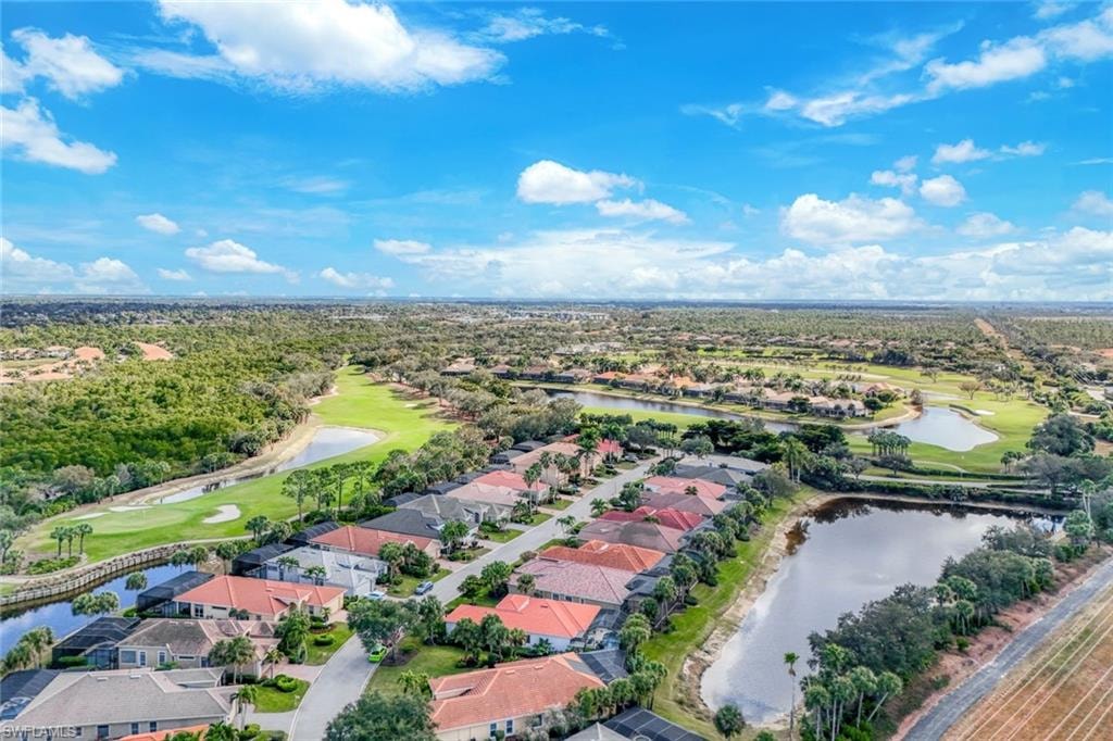 Aerial view of residential area featuring a golf club and a nearby body of water