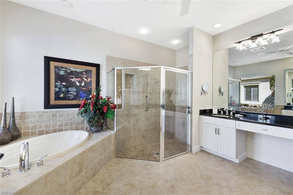Bathroom featuring vanity, ceiling fan, a garden tub, light tile patterned floors, and a stall shower