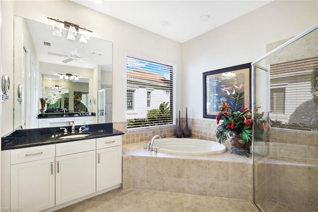Bathroom with vanity, a garden tub, a shower stall, and light tile patterned floors