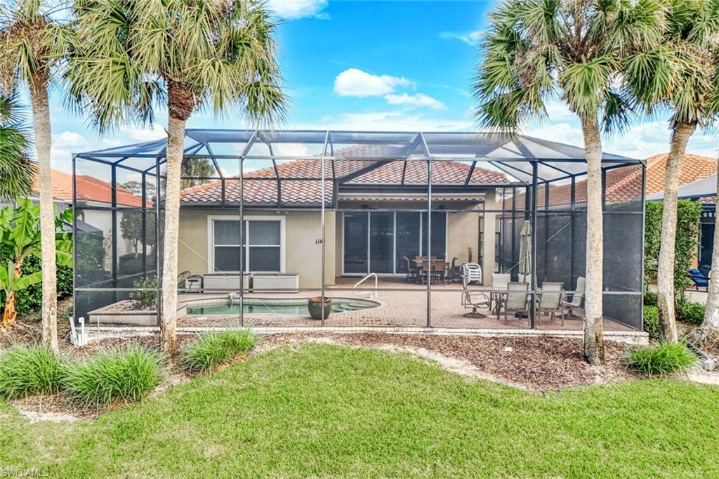Rear view of property featuring a sunroom, an outdoor pool, a lanai, and a patio