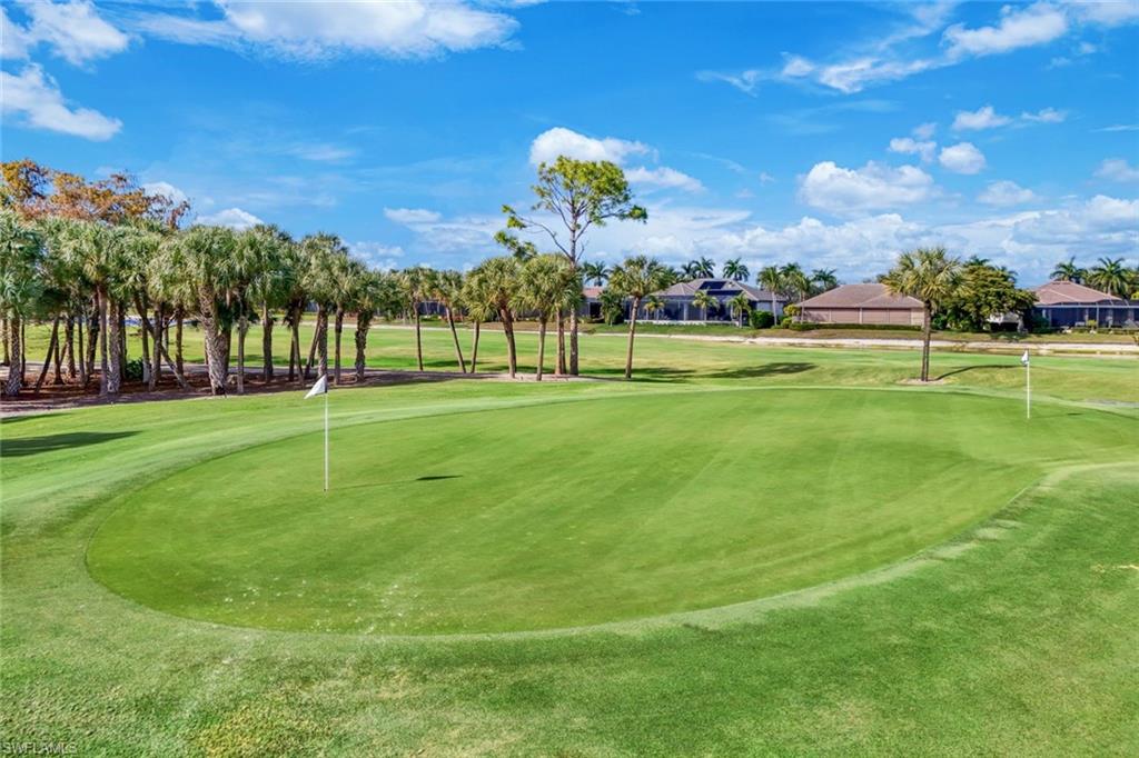 View of property's community featuring a putting area, view of golf course, and a yard