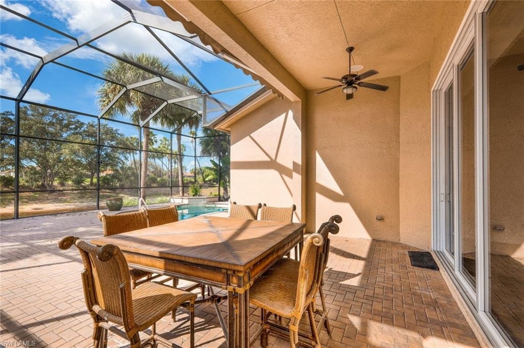 View of patio / terrace with a ceiling fan, outdoor dining space, a sunroom, a lanai, and an outdoor pool