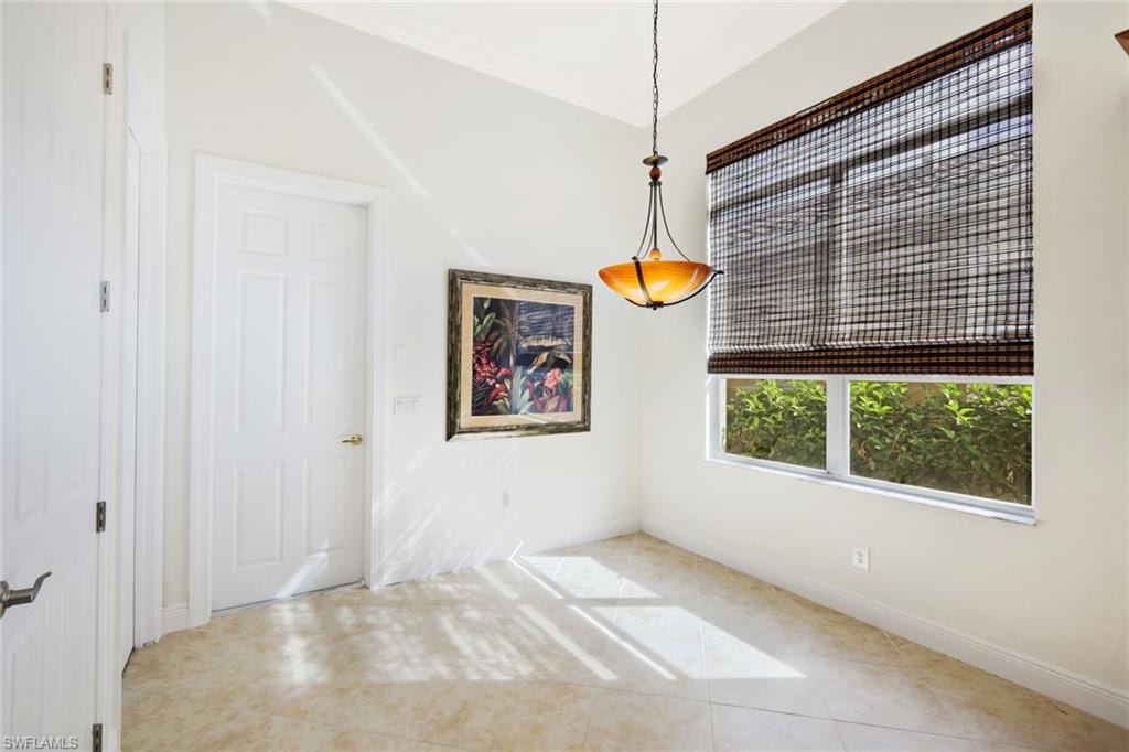 Unfurnished dining area with tile patterned floors and baseboards