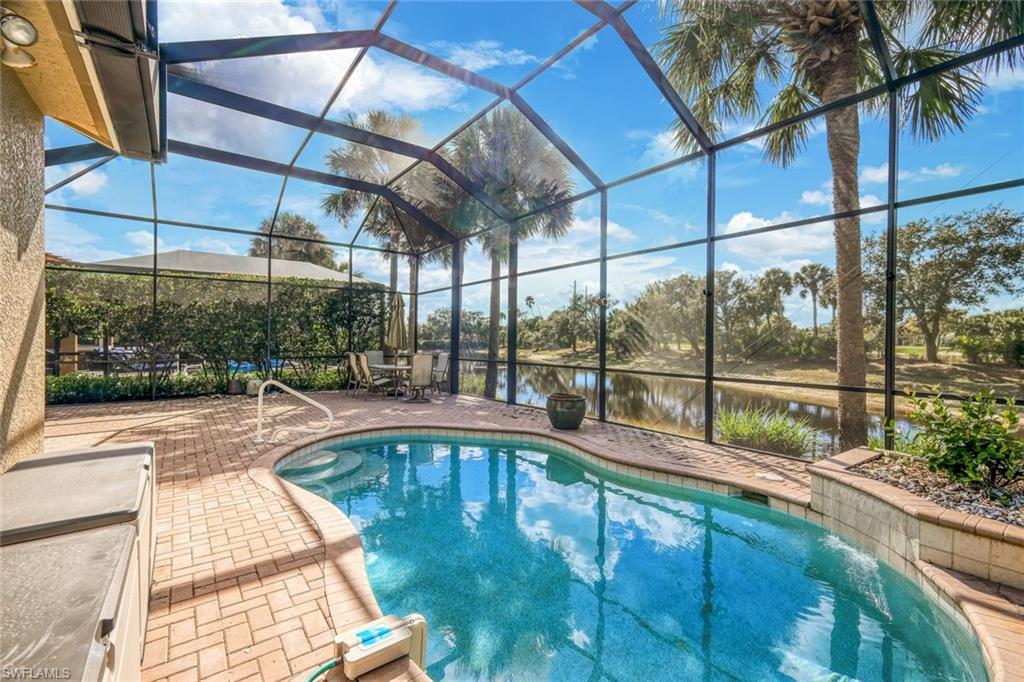 Swimming pool with a lanai, a sunroom, a water view, and a patio