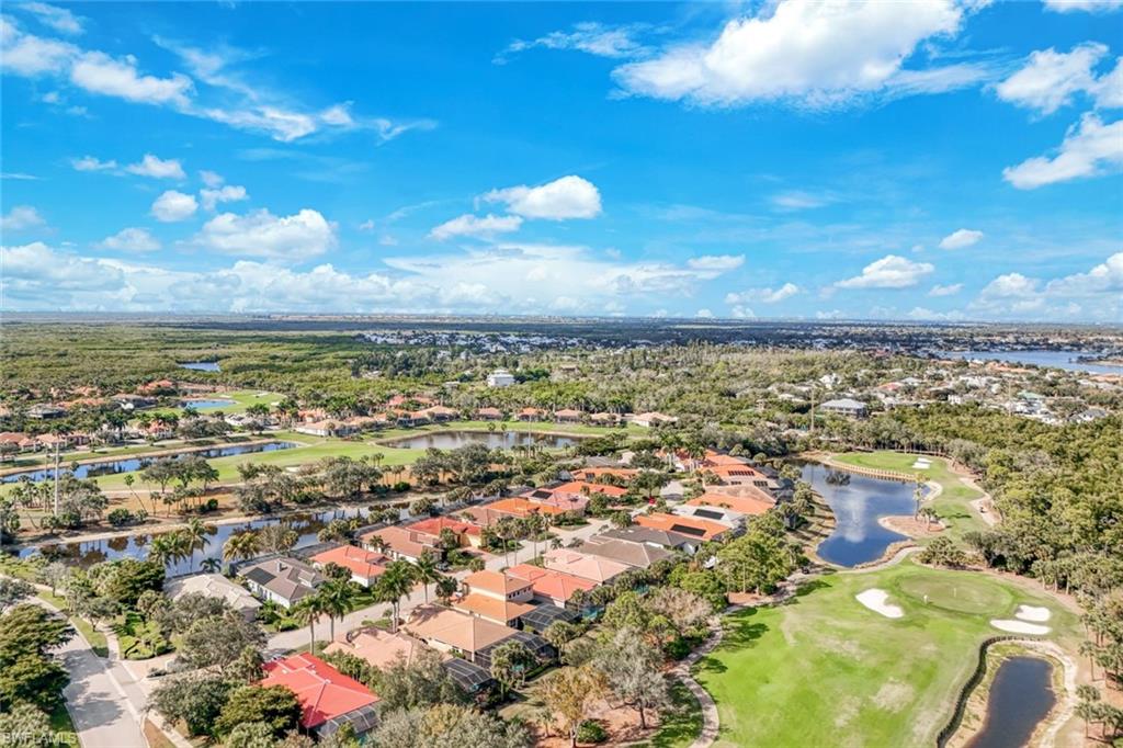 Aerial view of residential area with a golf course and a nearby body of water